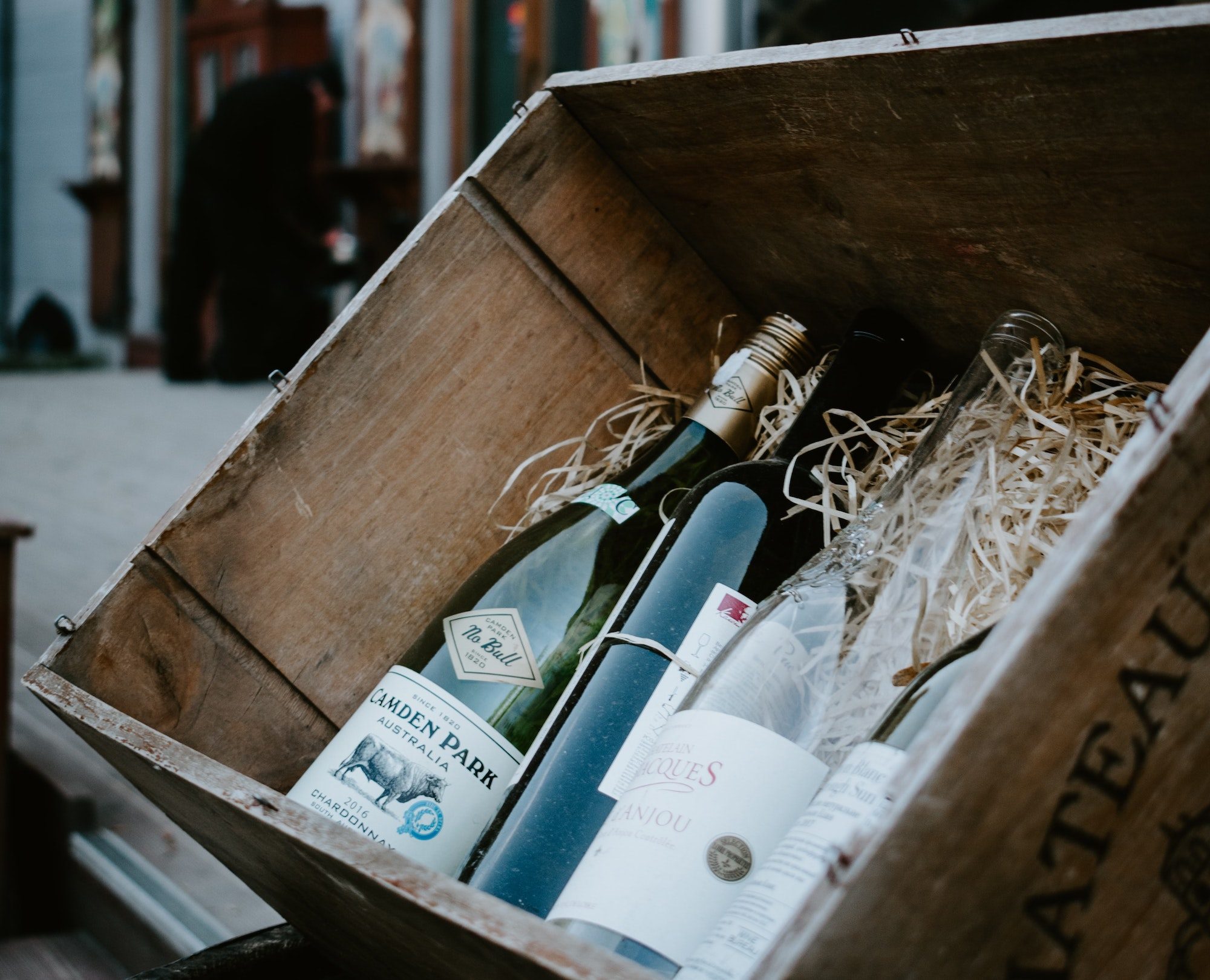 Weinflaschen liegen in einer hölzernen Transport-Box