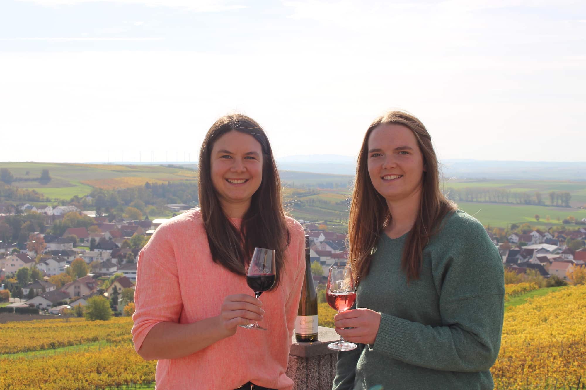 Ronja und Selina Clemens, Jungwinzerinnen mit Weingläsern vor den Weinbergen