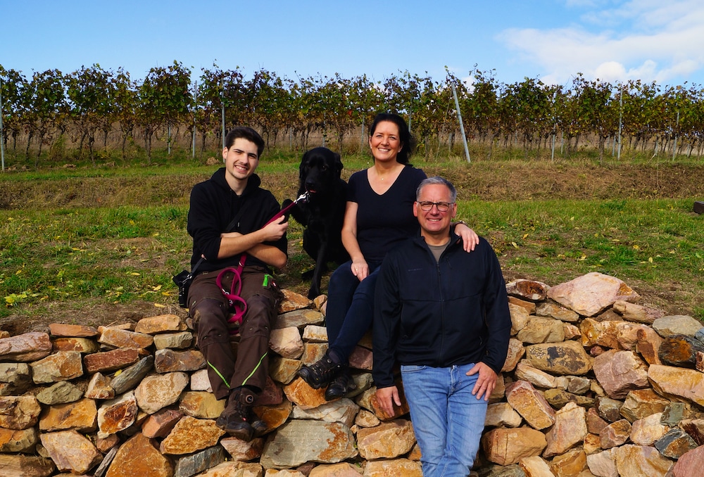 Die Winzer-Familie vom Weingut Großmann-Bergmann posieren vor den Weinreben ihres Betriebes