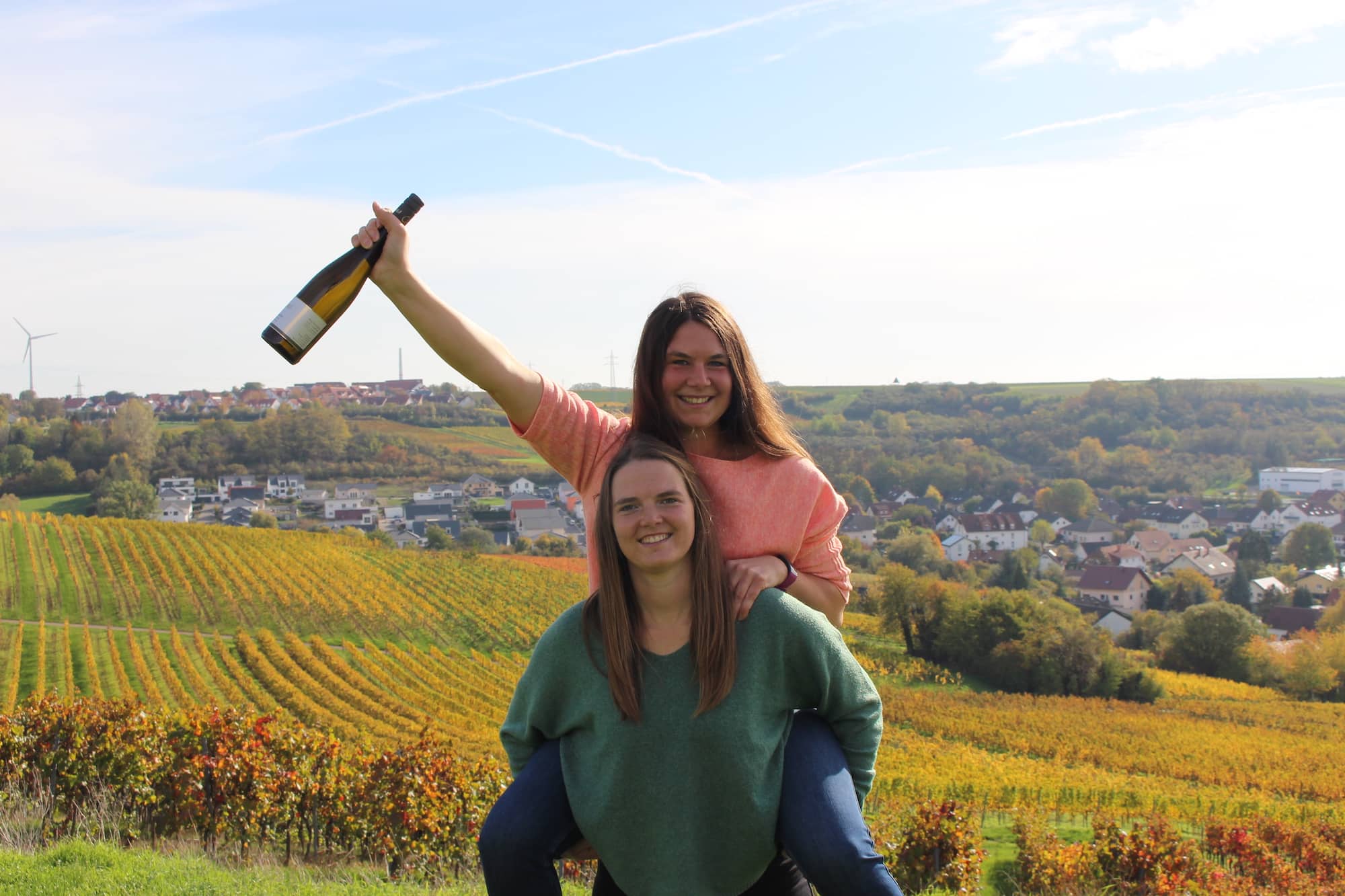 Die Jungwinzerinnen Ronja und Selina Clemens vom Wein vom Weingut Clemens vor den Weinbergen des Familienbetriebs