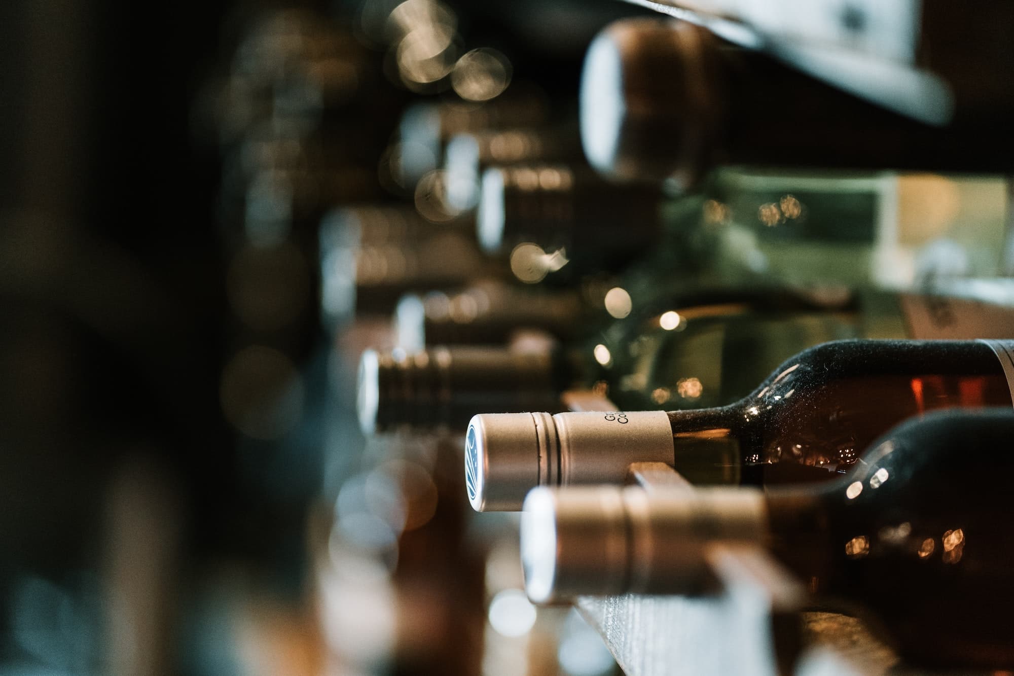 Weinflaschen liegen nebeneinander auf einem Weinregal